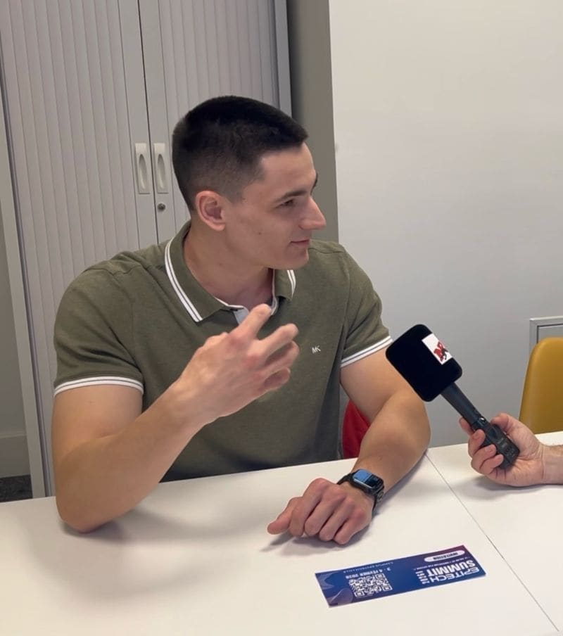 William Stoops explains STAXX at the NRJ microphone, an Epitech Summit invitation on the table